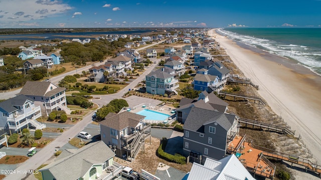 birds eye view of property featuring a view of the beach, a water view, and a residential view