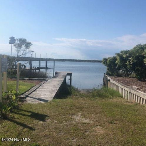 dock area with a water view and a yard