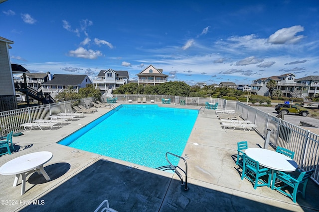 pool featuring a patio area, fence, and a residential view