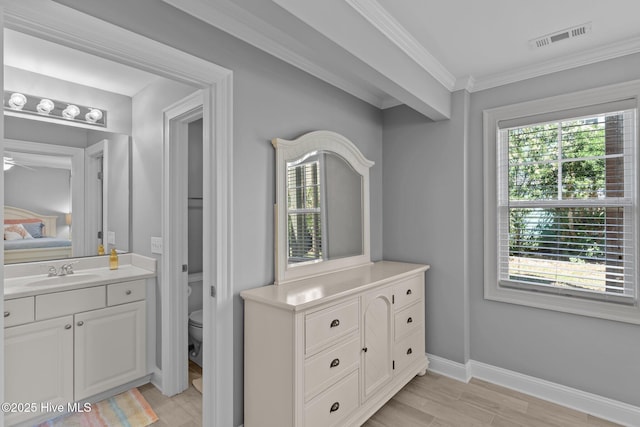 230 Third Ave Unit A, Kure Beach, NC 28449 - bathroom with healthy amount of natural light, toilet, wood finished floors, vanity, and crown molding