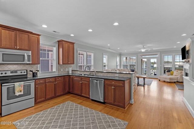 230 Third Ave Unit A, Kure Beach, NC 28449 - kitchen with appliances with stainless steel finishes, a peninsula, crown molding, open floor plan, and a sink