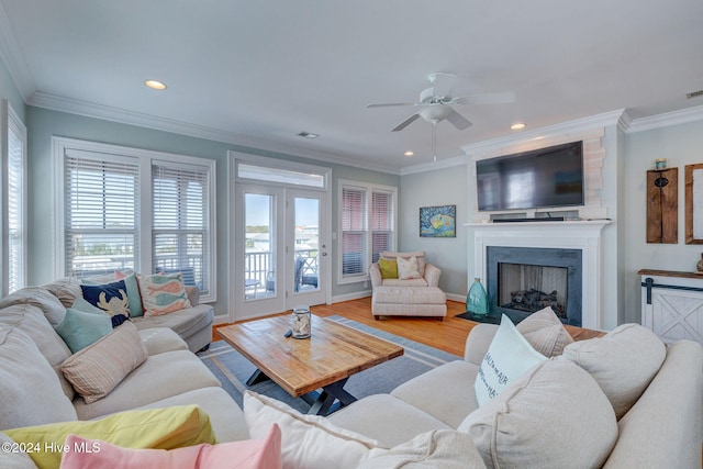 living room featuring light hardwood / wood-style floors, ceiling fan, and crown molding