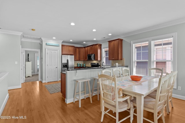 230 Third Ave Unit A, Kure Beach, NC 28449 - dining space featuring ornamental molding, baseboards, light wood-style floors, recessed lighting, and washer / clothes dryer