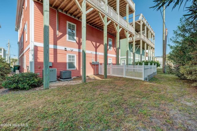 view of property exterior featuring central air condition unit and a lawn