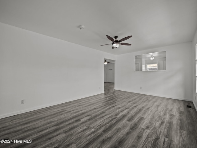 unfurnished living room with dark hardwood / wood-style flooring and ceiling fan