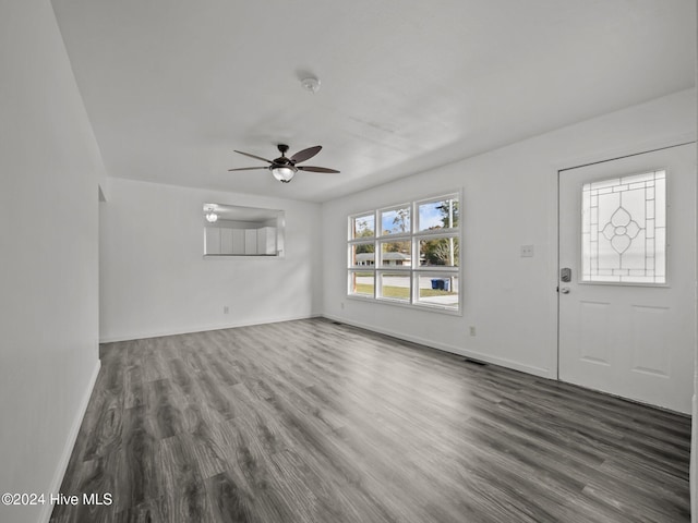 unfurnished living room featuring ceiling fan and dark hardwood / wood-style flooring