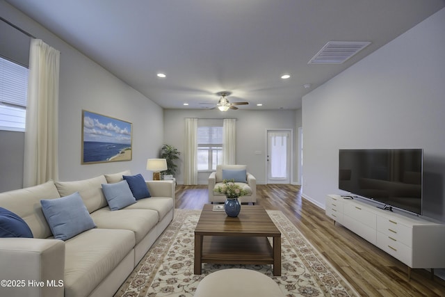 living room featuring wood-type flooring and ceiling fan