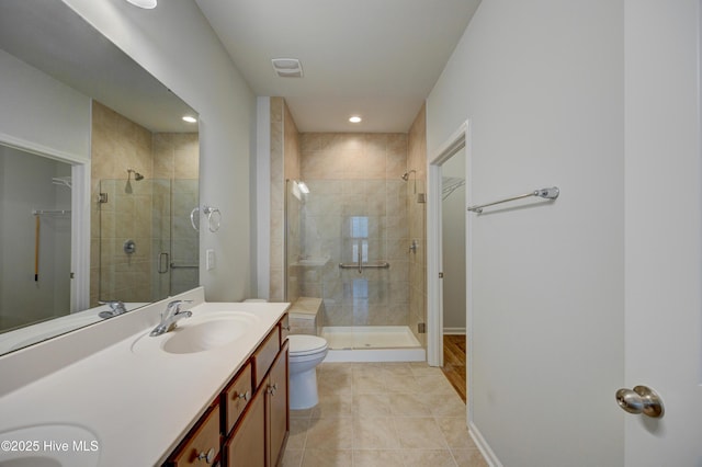 bathroom featuring tile patterned flooring, vanity, toilet, and a shower with door