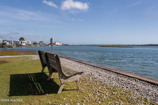 surrounding community featuring a water view and a lawn