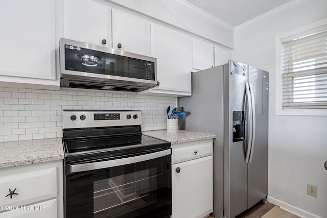 kitchen with light stone counters, white cabinets, decorative backsplash, ornamental molding, and appliances with stainless steel finishes