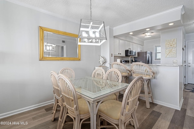 dining room featuring ornamental molding, dark wood-type flooring, and a textured ceiling