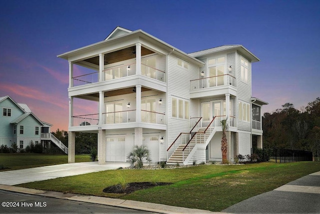 view of front facade featuring a lawn, a garage, and a balcony