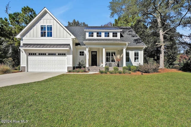 view of front of property with a porch, a garage, and a front lawn