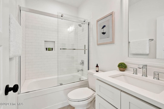 full bathroom with vanity, toilet, and bath / shower combo with glass door