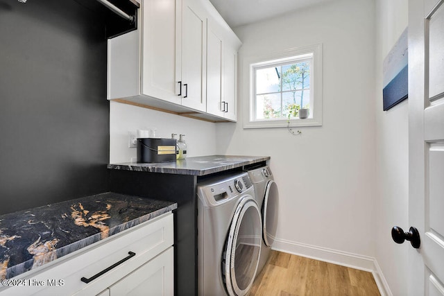 laundry area with cabinets, light hardwood / wood-style flooring, and washing machine and clothes dryer