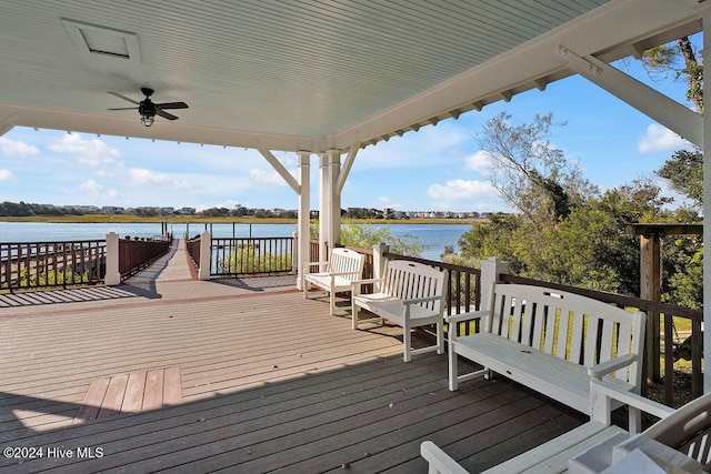 wooden deck with ceiling fan and a water view