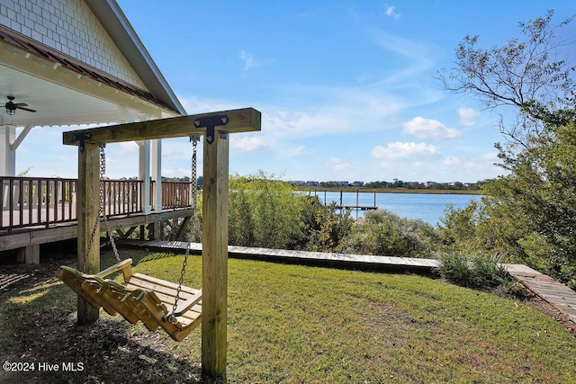 view of dock with a yard and a deck with water view