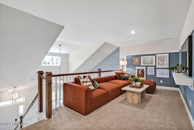 living room featuring vaulted ceiling, light colored carpet, and a notable chandelier