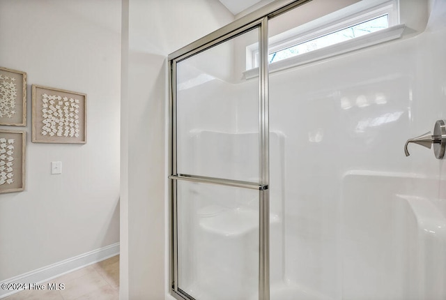 bathroom with walk in shower and tile patterned flooring