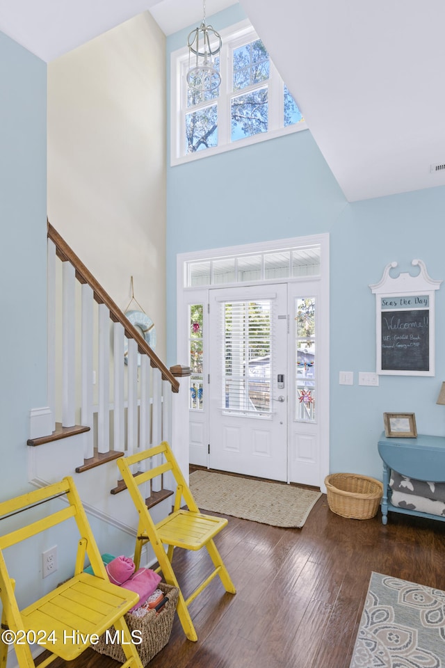 foyer entrance featuring plenty of natural light, a chandelier, a high ceiling, and dark hardwood / wood-style flooring