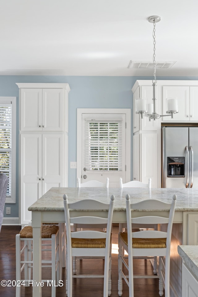 dining space featuring dark hardwood / wood-style flooring and a notable chandelier