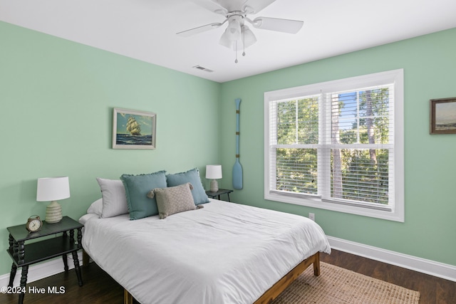 bedroom with dark hardwood / wood-style flooring and ceiling fan