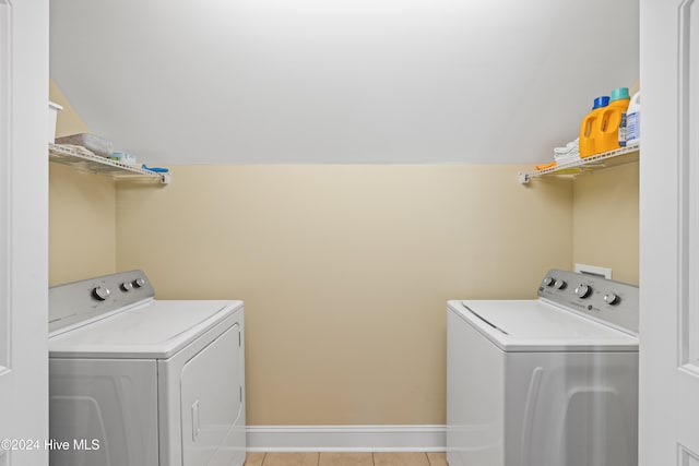 laundry area featuring washing machine and clothes dryer and light tile patterned flooring