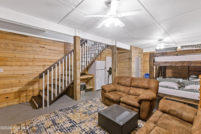 living room with wooden walls and ceiling fan