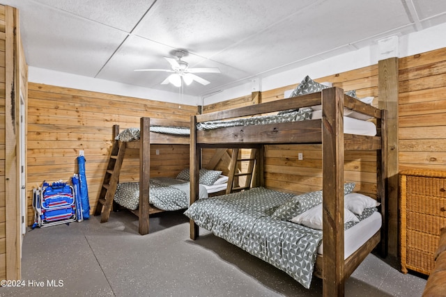 unfurnished bedroom with ceiling fan and wooden walls