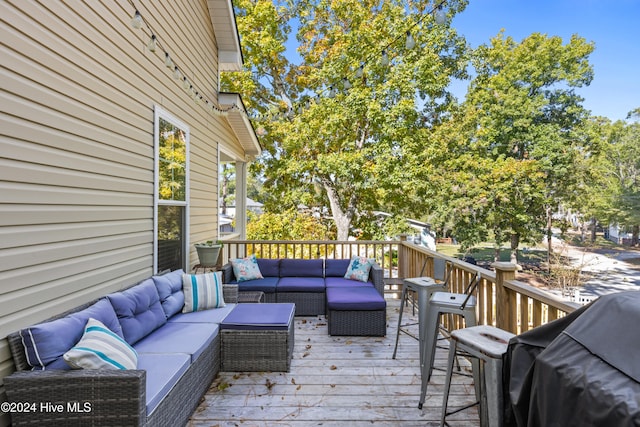 wooden terrace with an outdoor living space