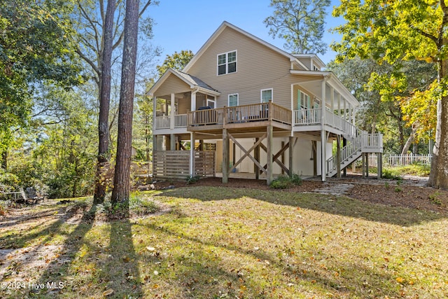 back of house featuring a lawn and a deck