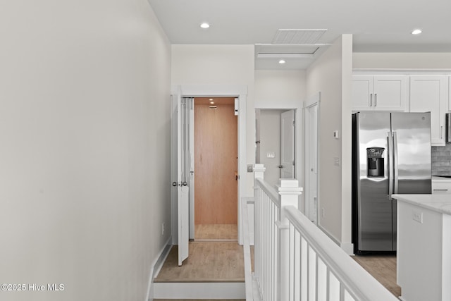 hallway with recessed lighting, an upstairs landing, attic access, and light wood-style floors