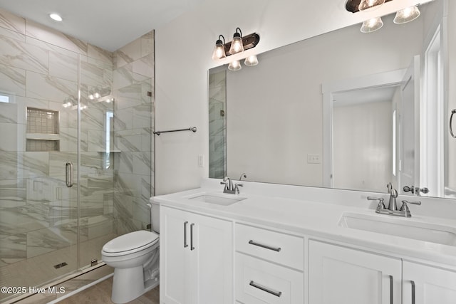 full bath with a stall shower, a sink, toilet, and double vanity