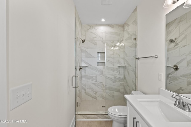 bathroom with vanity, a shower stall, and toilet