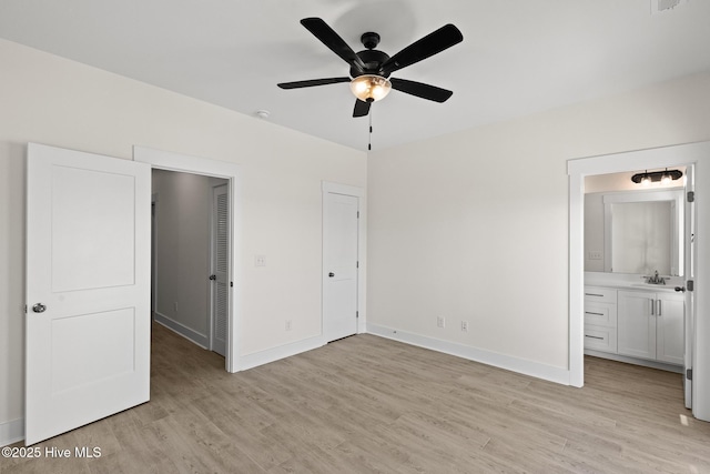 unfurnished bedroom with light wood-style floors, baseboards, and a sink