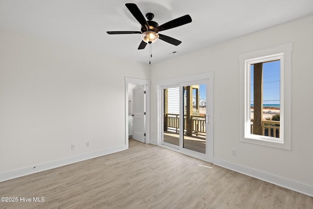 unfurnished room featuring light wood-type flooring, visible vents, baseboards, and a ceiling fan