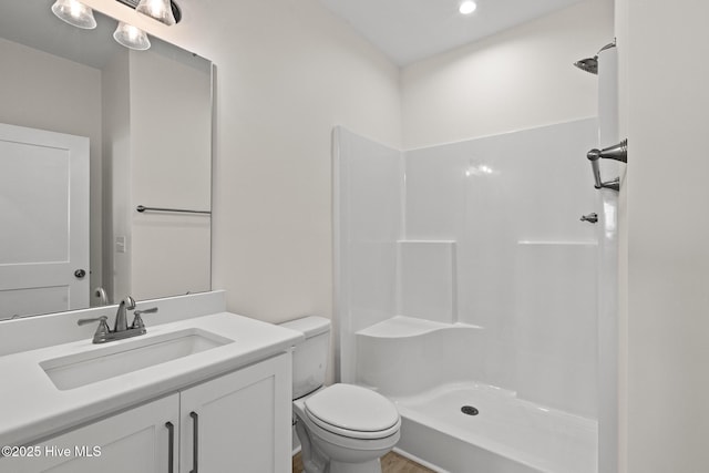 bathroom featuring a shower, vanity, and toilet