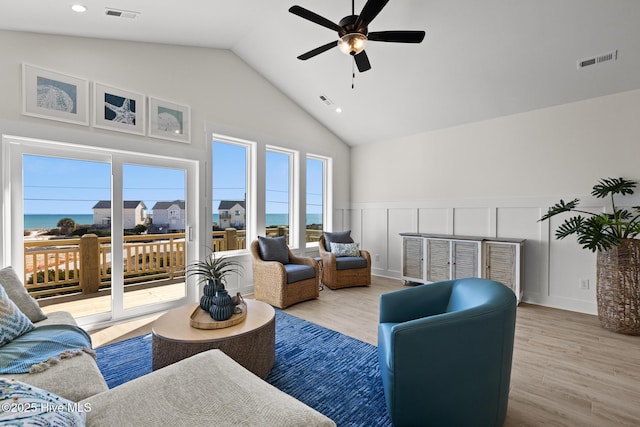 living area featuring light wood-style floors, visible vents, and a ceiling fan