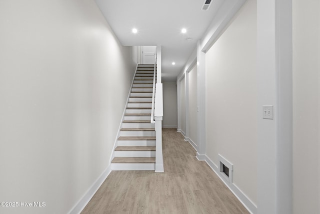 hallway with light wood finished floors, baseboards, visible vents, stairway, and recessed lighting