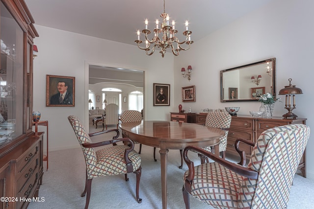 dining room featuring light carpet and a notable chandelier