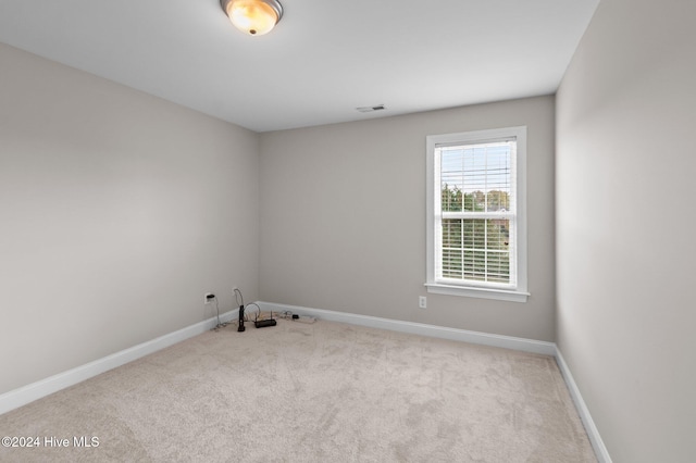 spare room featuring light colored carpet