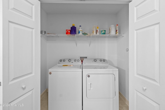 washroom featuring washer and clothes dryer and light tile patterned flooring