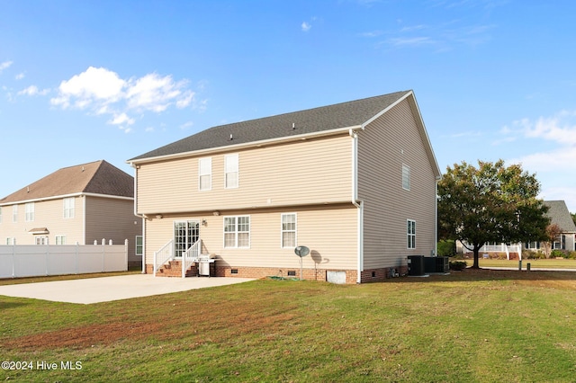 rear view of property with central AC unit, a yard, and a patio area