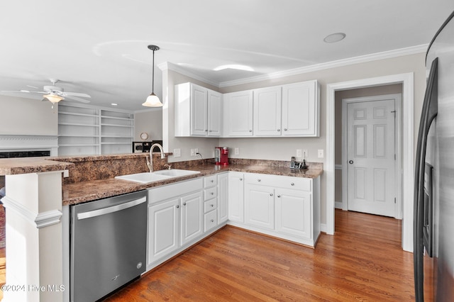 kitchen with white cabinets, kitchen peninsula, appliances with stainless steel finishes, and sink