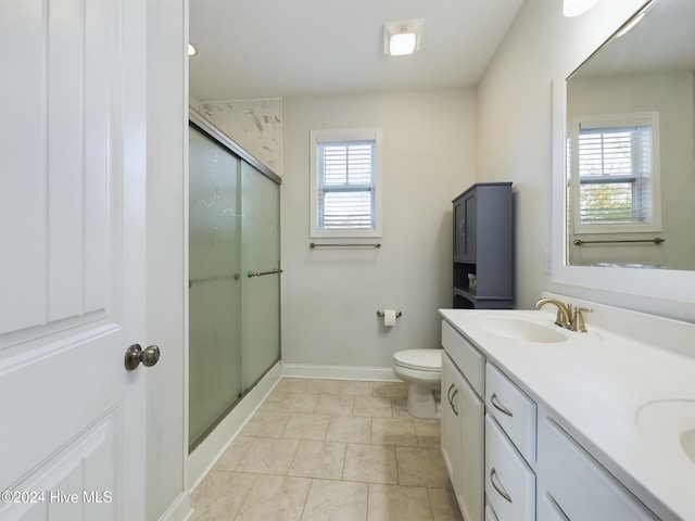 bathroom featuring tile patterned flooring, vanity, toilet, and an enclosed shower