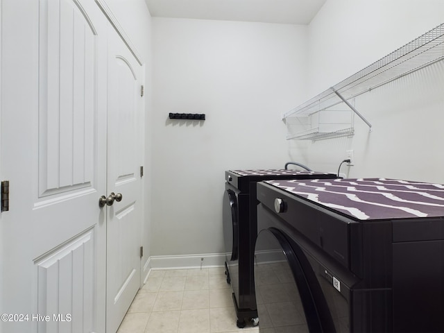 laundry room with light tile patterned flooring and washing machine and clothes dryer