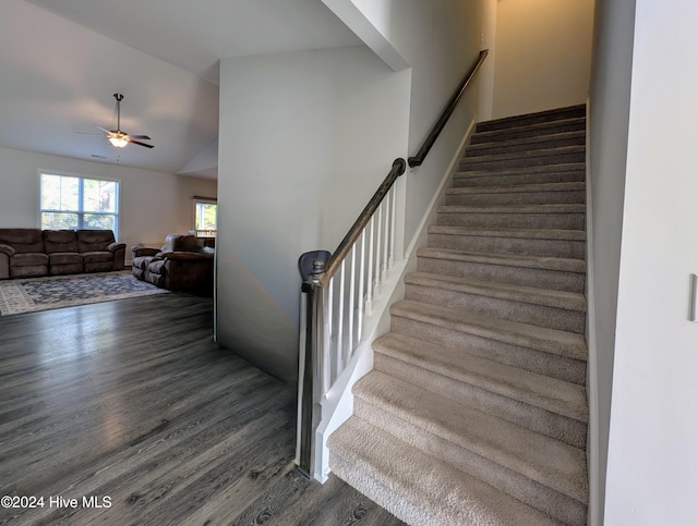 staircase with ceiling fan, wood-type flooring, and vaulted ceiling