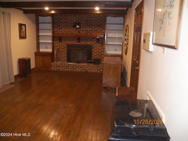 unfurnished living room featuring a fireplace, beamed ceiling, and dark hardwood / wood-style floors