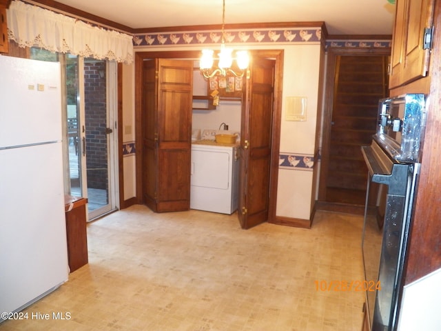 kitchen featuring black fridge, washer / dryer, white refrigerator, pendant lighting, and a chandelier