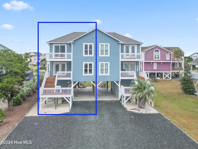 view of front of home featuring a front lawn, a balcony, and a carport